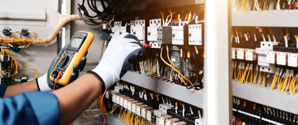 Engineer carrying out electrical testing on commercial fuseboard